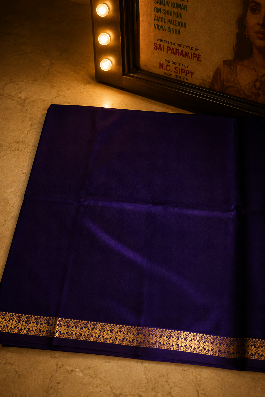 Handwoven royal purple Chanderi saree with intricate gold zari border displayed on a wooden hanger.