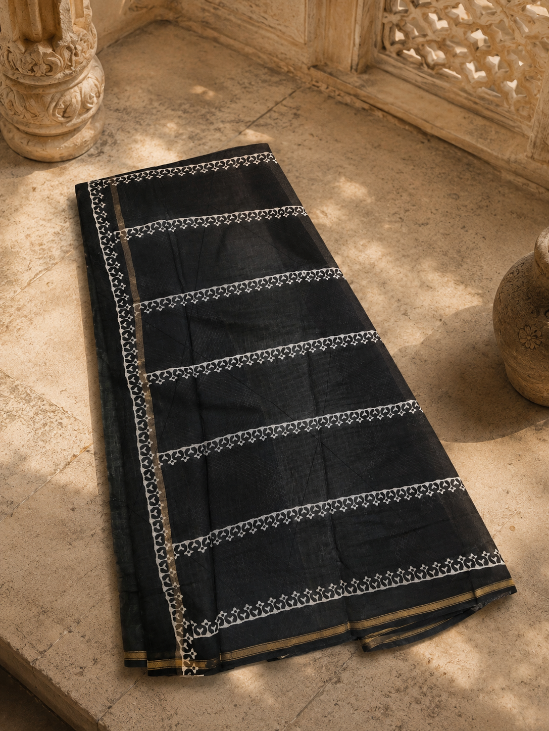 Folded black Chanderi handloom saree showcasing premium fabric and woven zari border.