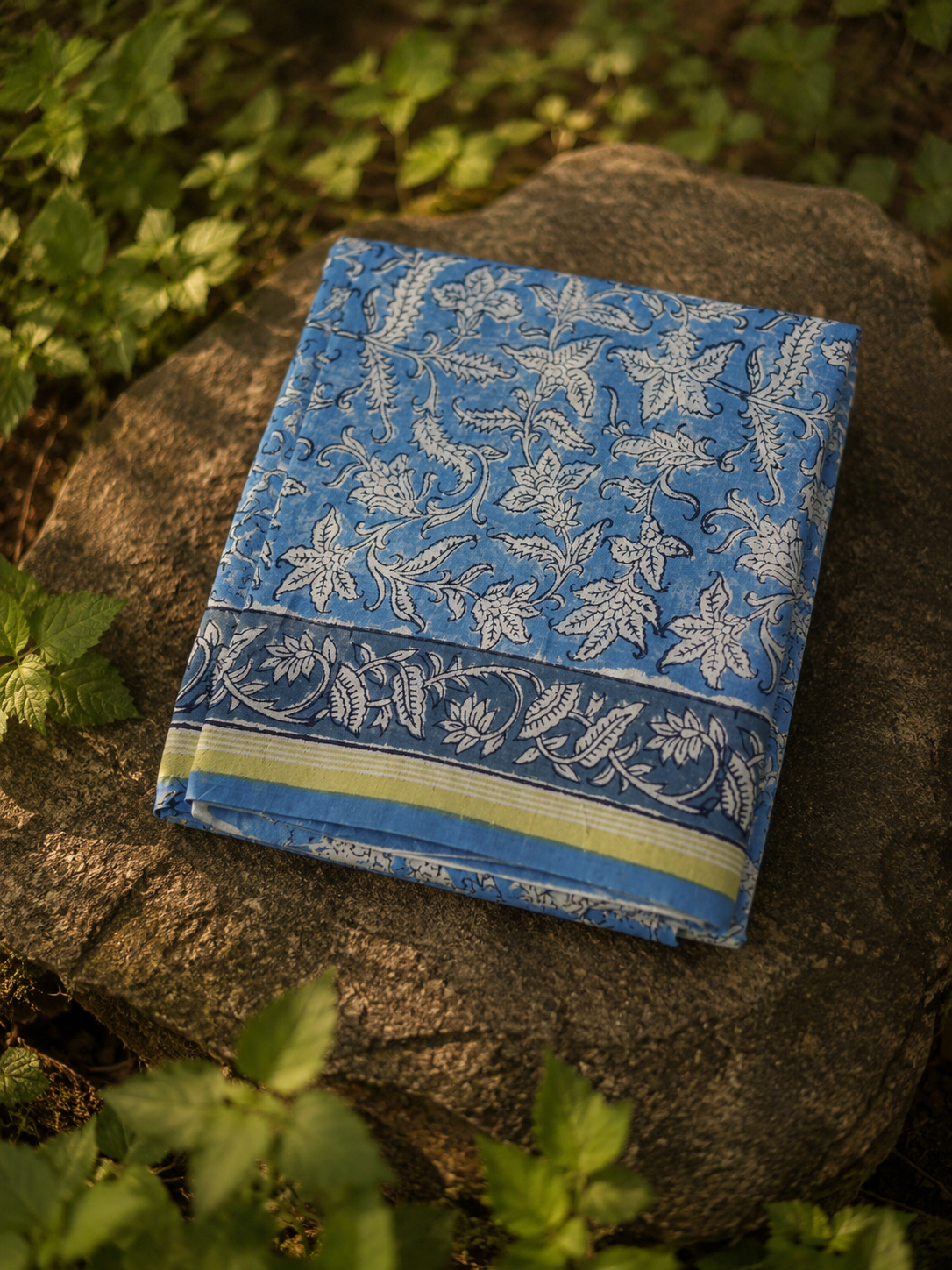 Folded blue Chanderi suit set showcasing traditional floral hand block print and zari border.